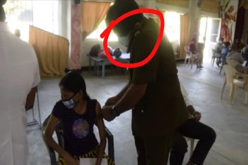 காதில் தொலைபேசியுடன் தடுப்பூசி போட்ட சுகாதார பரிசோதகர் - அழுதபடி வெளியேறிய யுவதி