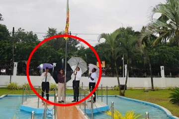 யாழில் குடை பிடித்து தேசிய கொடியை ஏற்றிய அமைச்சர்; கடும் விசனம் !