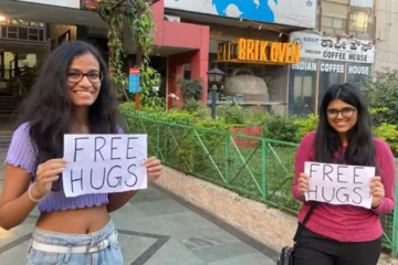 இலவச கட்டிப்புடி வைத்தியம் - நூதன முயற்சியில் இறங்கிய இளம்பெண்கள்!