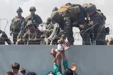 காபூலில் முள்வேலியைத் தாண்டி கொடுக்கப்பட்ட குழந்தையை வாங்கிய இராணுவ வீரர்: குழந்தை எங்கே?