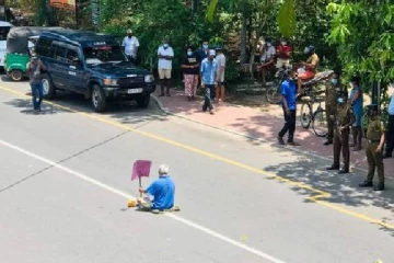 அரசாங்கத்தை கண்டித்து  நடுவீதியில்   அமர்ந்த வயோதிபர்!