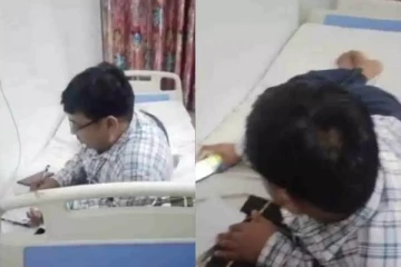 நோயாளியின் படுக்கையில் படுத்தவாறு வேலைபார்க்கும் மருத்துவர்: சர்ச்சை வீடியோ வைரல்
