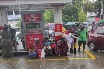 கொட்டும் மழையையும் பொருட்படுத்தாமல் குழந்தைகளுடன் காத்திருக்கும் மக்கள்!