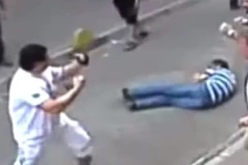 සංචාරකයෙකුට පාර දිගේ එලවමින් අතින් පයින් පොලුවලින් ඉතා බිහිසුණු ලෙස පහර දෙයි..