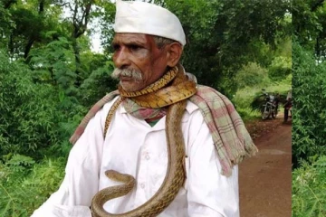 கழுத்தில் சுற்றியிருக்கும் பாம்பு: கூலாக சைக்கிள் ஓட்டிச்செல்லும் முதியவர்