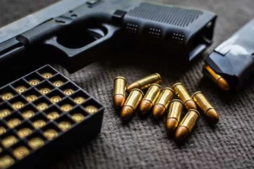 ගිනි අවියක් හා ජීව උන්ඩ තොගයක් සමඟ පුද්ගලයෙක් කොටුවෙයි.