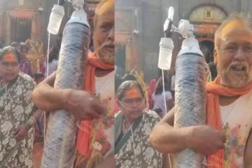 மனைவிக்காக ஆக்சிஜன் சிலிண்டர் சுமந்தபடியே கோவிலுக்கு சென்ற கணவர்