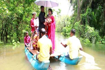 வீதிகள் வெள்ளத்தில் மூழ்கியதால் தோணியில் வந்த மணமக்கள்!